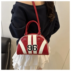 Détail du sac bowling rouge avec rayures blanches et broderie numéro 96