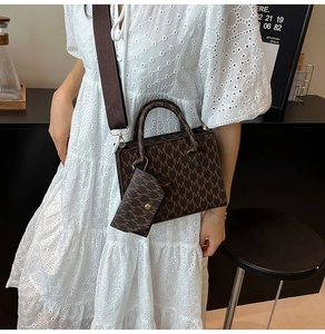 Close-up of brown monogram tote bag set with wide shoulder strap and mini coin purse