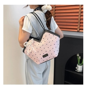Pink tote bag detail with black bows, lace pearl charm and contrast shoulder strap
