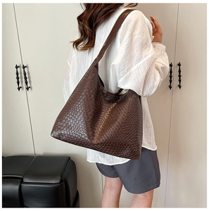 Detail of dark brown tote bag with woven texture worn by model for daily outfit