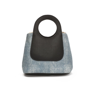 Contrast denim bucket bag with silver studs and black leather circular handles