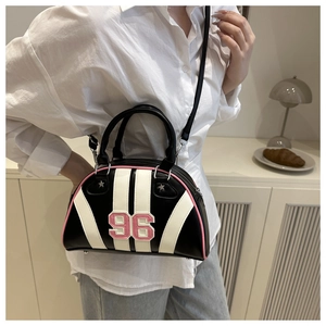 Détail d'un sac demi-lune avec le numéro 96 brodé en rose et un motif à rayures chic