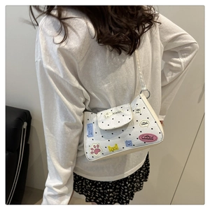 Vista posteriore dettagliata della borsa bianca a pois con toppe cartoon indossata dal modello