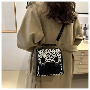 Back view of leopard print crossbody bag styled with a khaki trench coat and leather trim