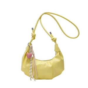 Minimalist bright yellow half-moon crossbody bag with a pink heart charm and knot strap