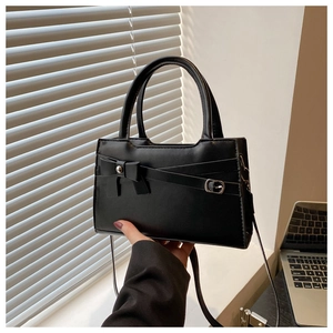 Détail du sac bandoulière noir avec nœud élégant et boucle métallique argentée
