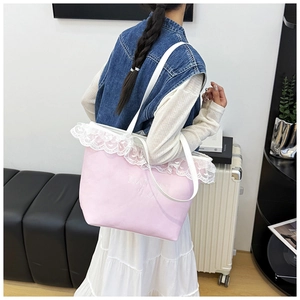 Detailed side view of pink canvas tote bag with white lace trim and embossed lettering