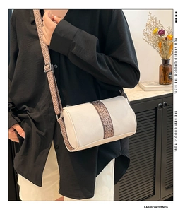 Close-up of cream Boston bag with litchi grain texture and ethnic geometric strap
