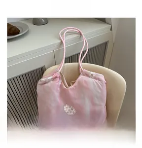 Detail of pink tie-dye fabric tote bag with 3D white flower embroidery and thin handles