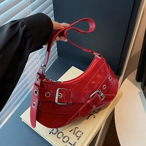 Chic red patent leather crescent underarm bag with silver grommets and buckle details