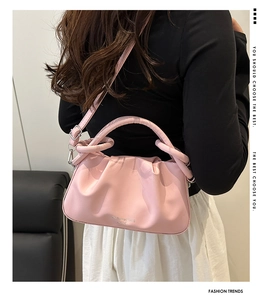 Dettaglio della borsa nuvola rosa a pieghe con texture morbida e logo argento con tracolla