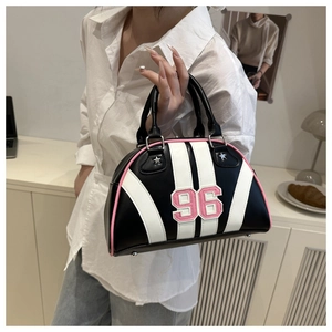 Détail du sac Boston avec broderie 96 et finitions roses sur cuir synthétique noir