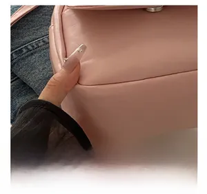 Detail shot of precise stitching and smooth pink leather texture on a mini backpack