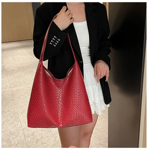 Detail of red hand-woven leather tote bag showing large capacity and soft texture