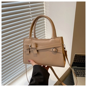 Détail du sac à main en cuir kaki avec nœud décoratif et bandoulière réglable