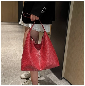Detail of red woven leather tote bag showing large capacity and textured shoulder straps