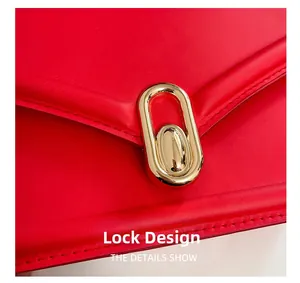 Détail d'un sac à bandoulière en cuir rouge avec fermoir doré et coutures élégantes