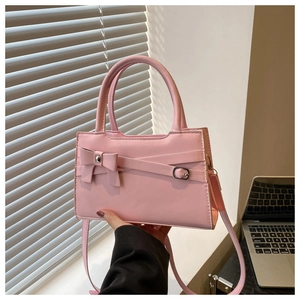 Gros plan du sac à main rose avec un nœud décoratif et une bandoulière réglable pratique