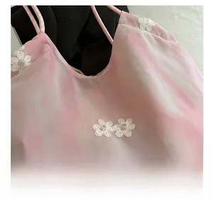 Detailed view of pink tie-dye chiffon fabric with elegant 3D white flower embroidery