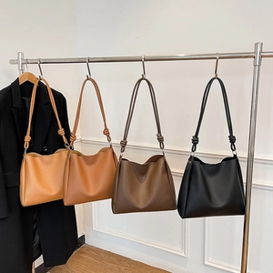 Sacs seau minimalistes en cuir marron et noir suspendus pour un style chic urbain