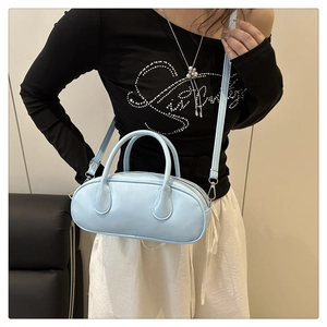 Light blue bowling bag in capsule shape with dual handles and adjustable strap for women