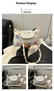 Detailed view of white polka dot shoulder bag with cute colorful patches and braided strap