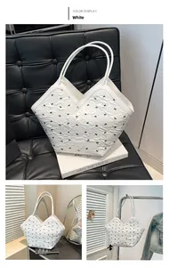 Detail of white tote bag featuring black bow patterns and elegant V-shaped opening design