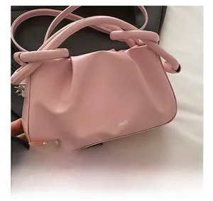 Detailed macro view of the pink pleated PU leather handbag with a unique knotted handle design