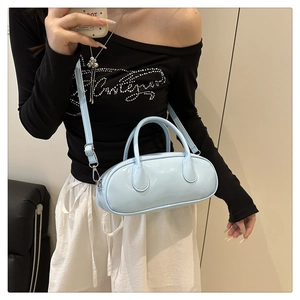 Detail of light blue glossy patent leather Boston bag with silver metal buckles