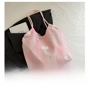 Detail of pink tie-dye tote bag with 3D floral accents and soft rope handles