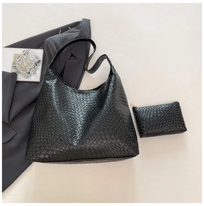 Detail of black woven leather tote and matching zipper pouch in a minimalist layout