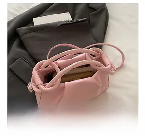Pink pleated crossbody bag showing internal capacity with phone and long wallet