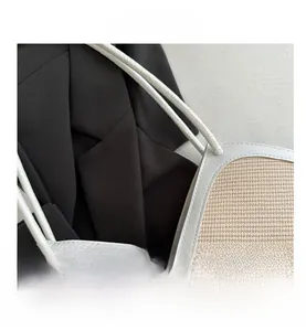 Close-up of hand-woven tote bag showing white leather trim and detailed V-shaped stitching
