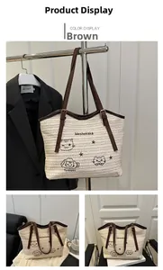 Detail of woven straw tote bag featuring cute cat embroidery and brown leather straps