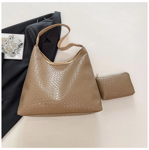 Detail shot of a large beige textured tote bag with a matching small zipper pouch set