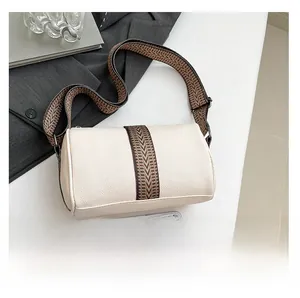 Creamy white cylindrical pillow bag with vintage geometric pattern wide strap and phone size reference