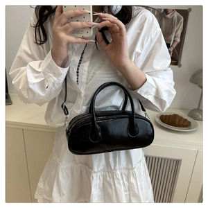 Detail of black oil wax PU leather Boston bag with silver zipper and adjustable strap