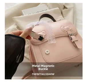 Detail view of the magnetic buckle closure on pink leather backpack with lace bow