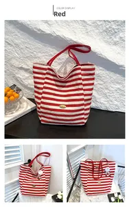 Detail der rot gestreiften Canvas-Tasche mit goldenem Handmade-Metallemblem