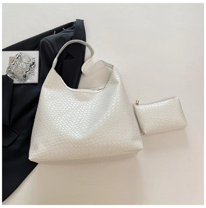 Detail shot of white woven tote bag set with matching zipper pouch on minimalist background