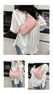 Detail of pink crescent underarm bag with silver bow accent and leather texture