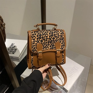 Retro leopard print backpack with brown leather accents and metal buckle straps