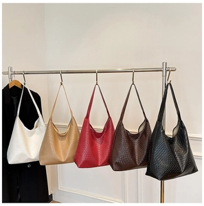 Detailed row of woven hobo tote bags in cream, gold, red, brown, and black colors