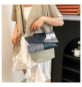 Borsa a tracolla nera con motivo serpente abbinata a un outfit moderno da donna