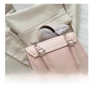 Detail of adjustable metal buckle and pink leather strap with decorative lace ribbon