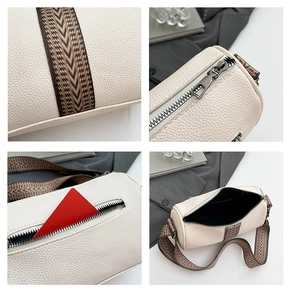 Detail of lychee textured cream cylinder bag featuring vintage woven strap and zipper