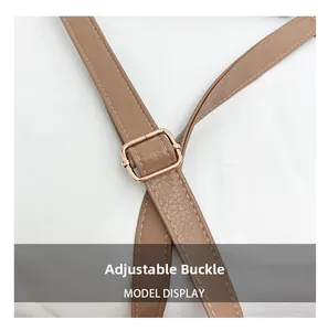 Close-up of adjustable khaki faux leather strap with golden metal buckle and fine stitching