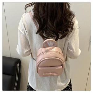 Detail of pink bow mini backpack for women showing vegan leather texture and silver buckle