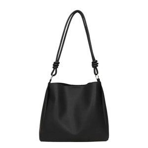 Sac seau minimaliste en cuir noir avec bandoulière nouée et détails en argent