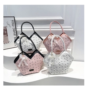 Detail of pink and white wrinkled fabric tote bags with bow prints and lace charms